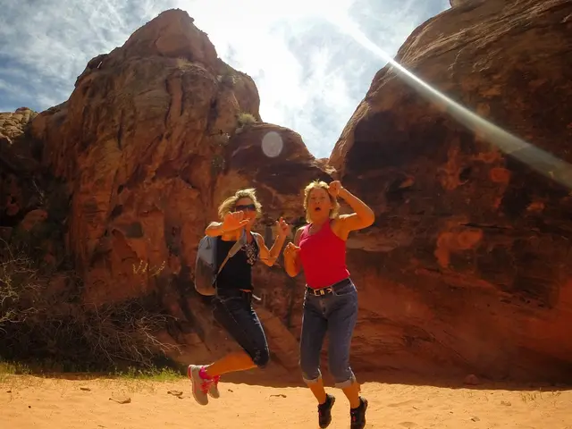 This image is clicked outside. There is sky at the top. There are two women in the middle. They are...