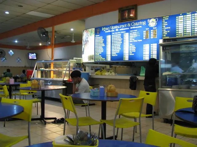 In this image it is a interior part of restaurant in which a man is sitting on the chair and there...